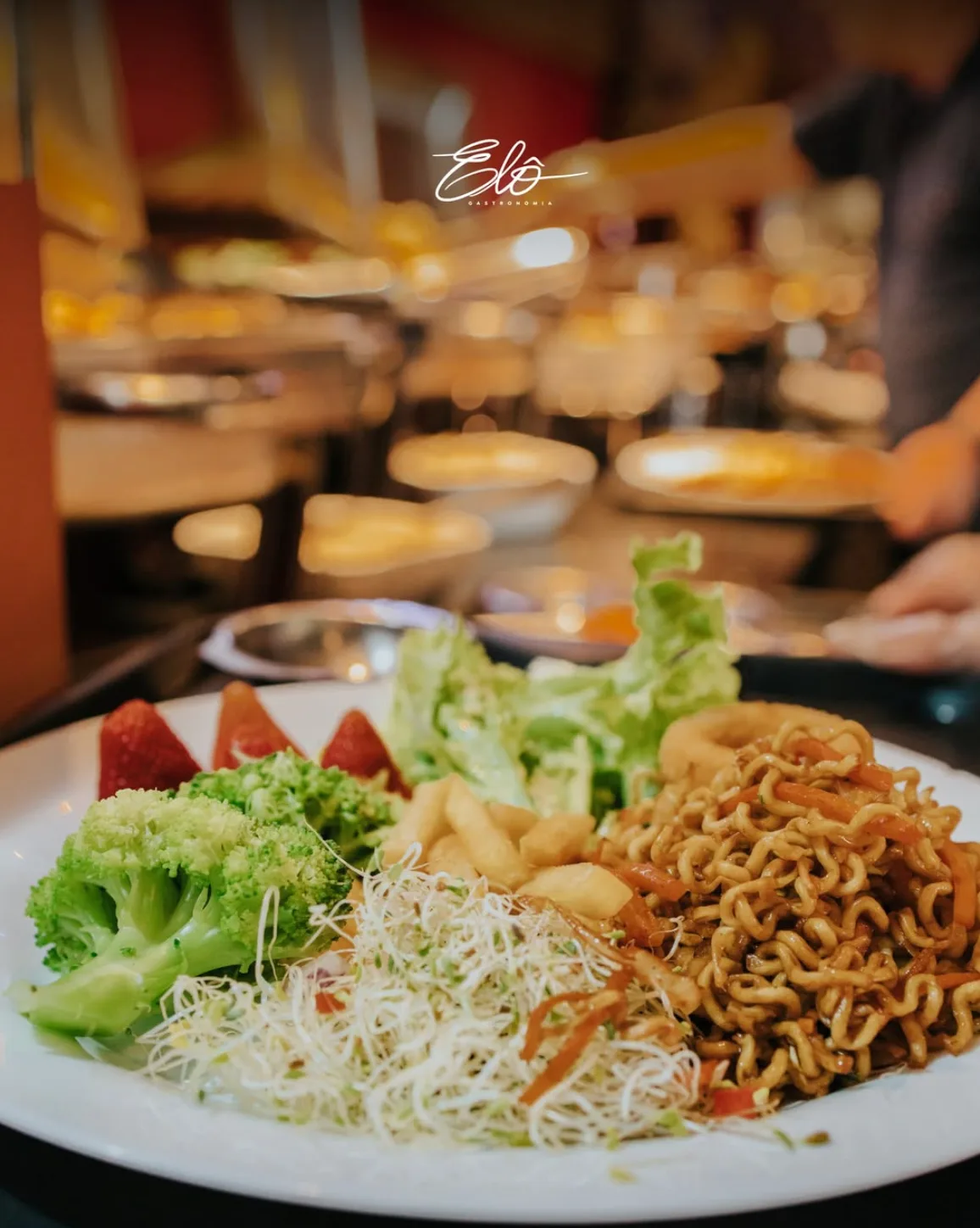 Prato montado no buffet do Elô Gastronomia com salada, legumes e yakisoba